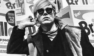 Promotional photograph of Andy Warhol in Moderna Museet, Stockholm, posing in front of Brillo boxes before the opening of his retrospective exhibition (1968)