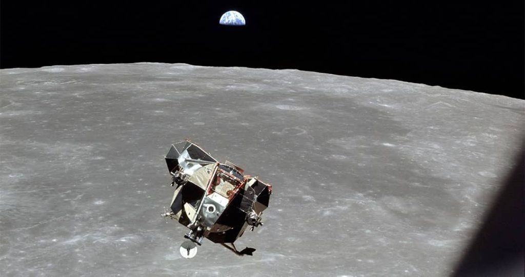 A view of the Apollo 11 Lunar Module 'Eagle' returning from the surface of the Moon to dock with the Command Module 'Columbia'. A half-illuminated Earth can be seen over the horizon (1969)