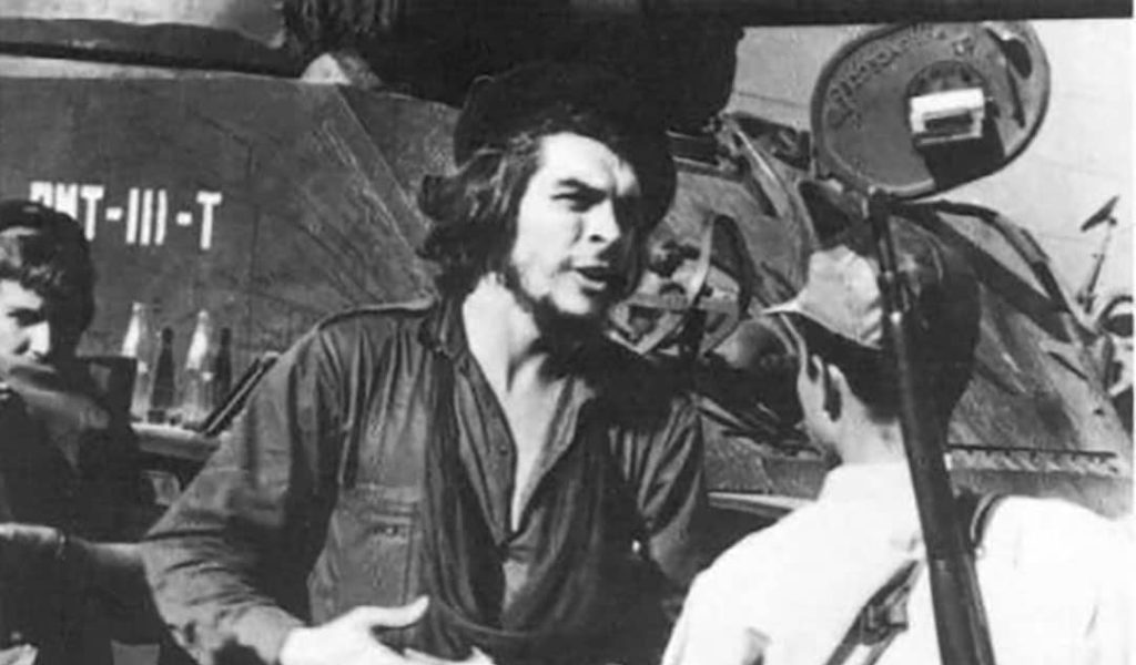 Ernesto 'Che' Guevara (centre) with other guerrilla soldiers and a tank in the background in Santa Clara, Cuba (1958)